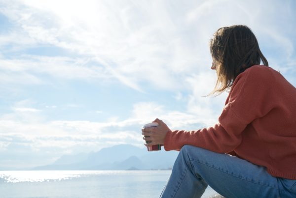 Woman sitting with cup of coffee looking into the distance